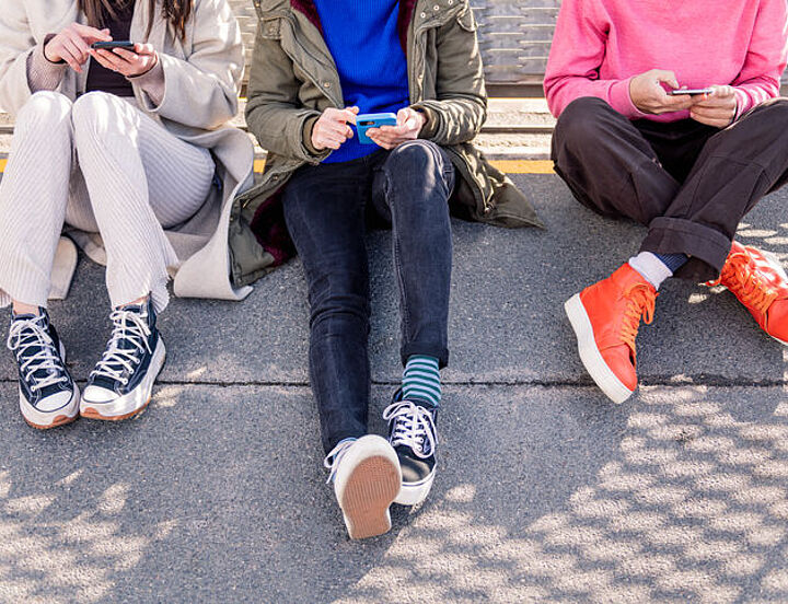 Freunde, die mit dem Telefon durch soziale Medien scrollen