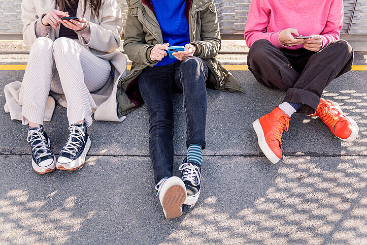 Freunde, die mit dem Telefon durch soziale Medien scrollen