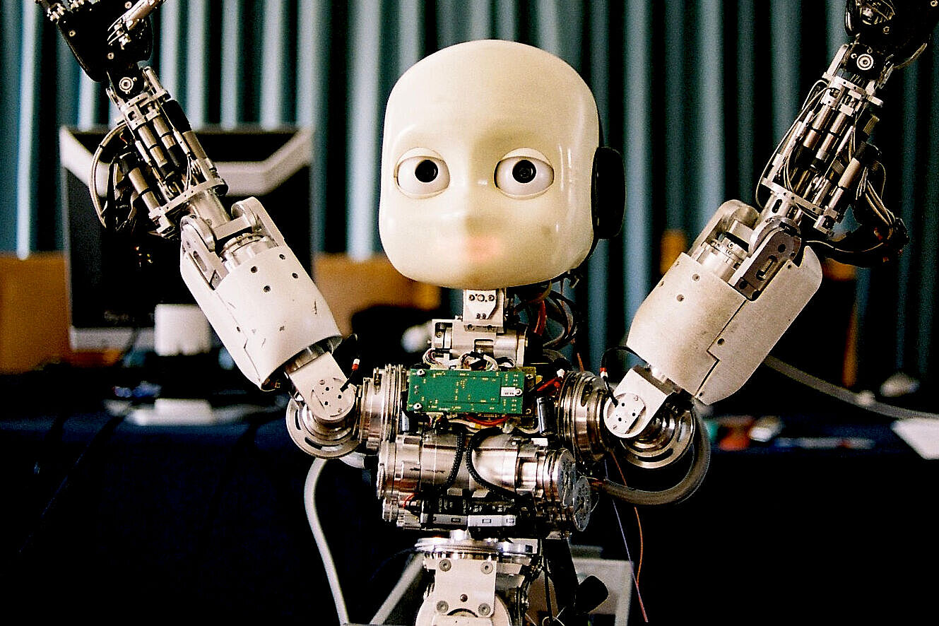 Das Bild zeigt einen Roboter, der seine Arme noch oben streckt. 