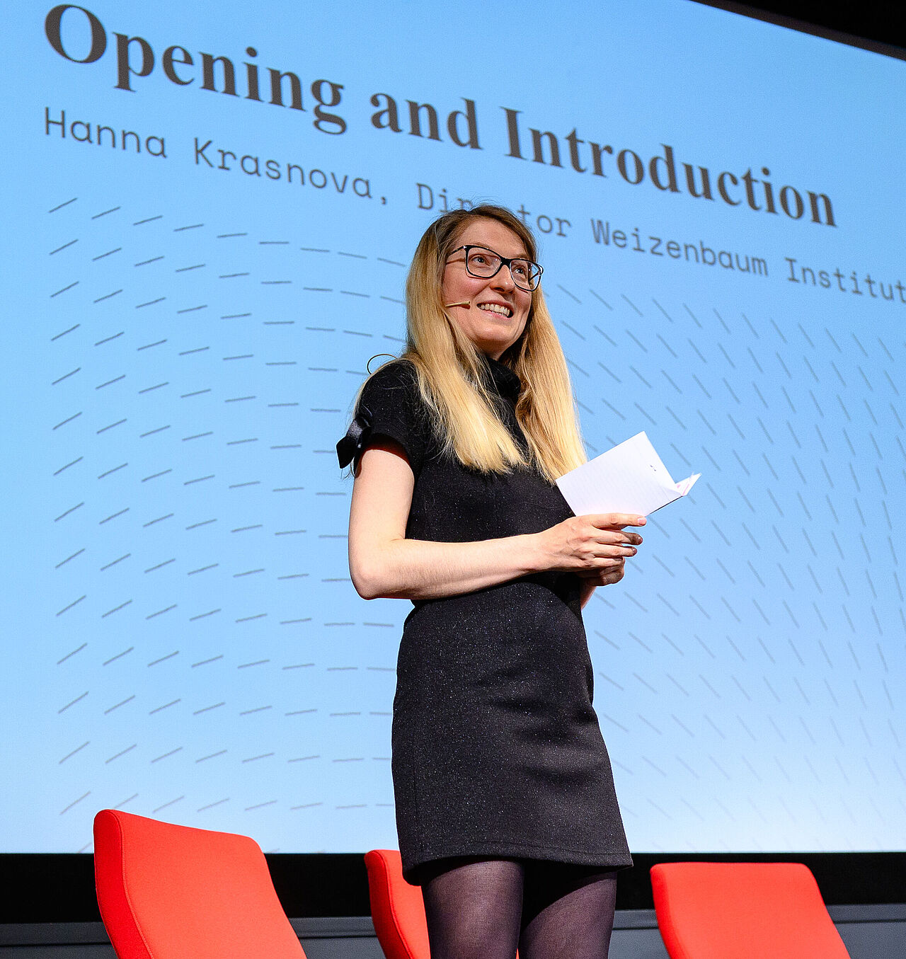 Hanna Krasnova, Direktorin des Weizenbaum-Instituts, steht auf der Bühne und begrüßt die Teilnehmenden zur zweiten Weizenbaum Conference